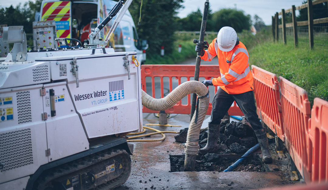 Employee repairing leak in the road